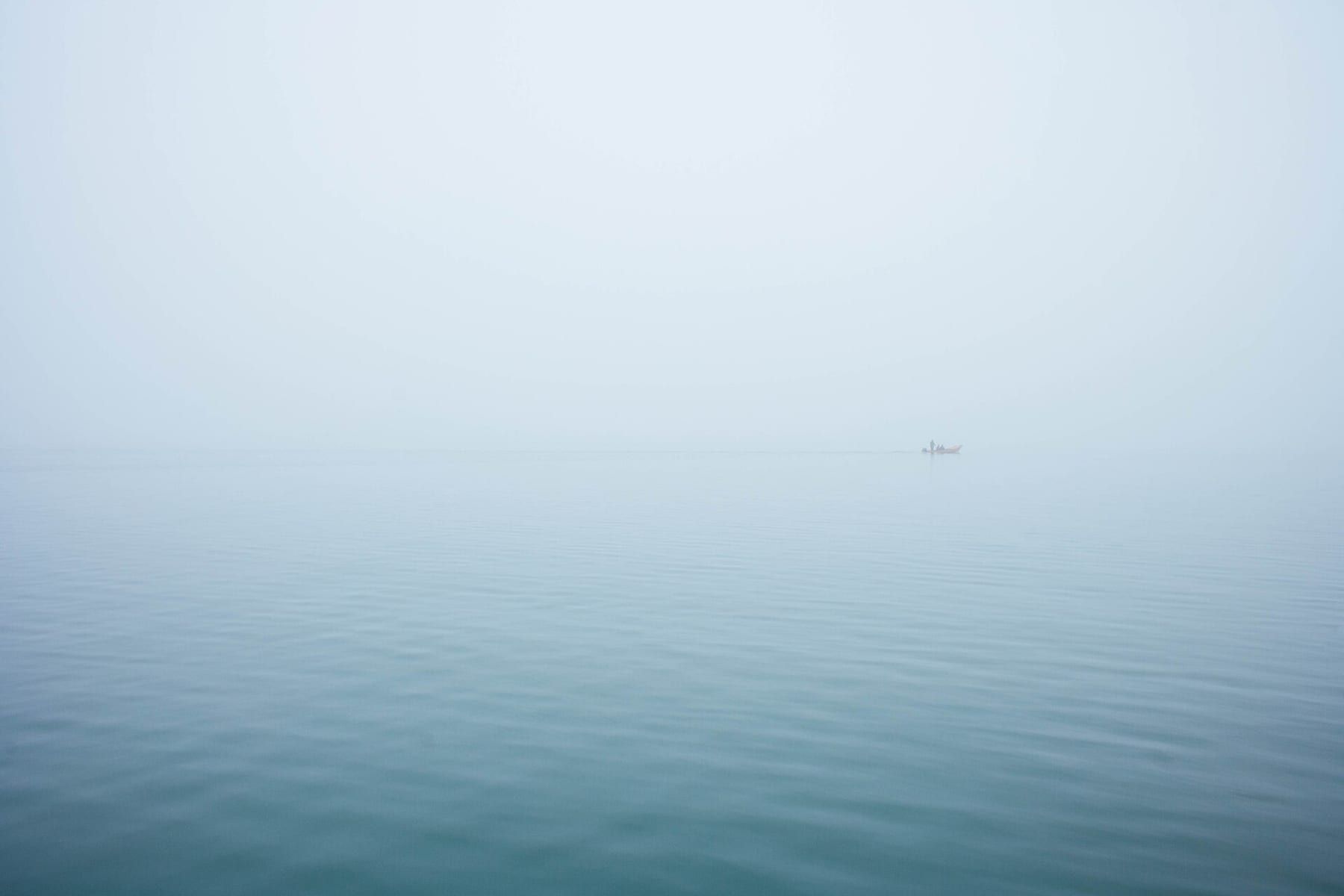 Laguna di Venezia nella nebbia con una barca in transito