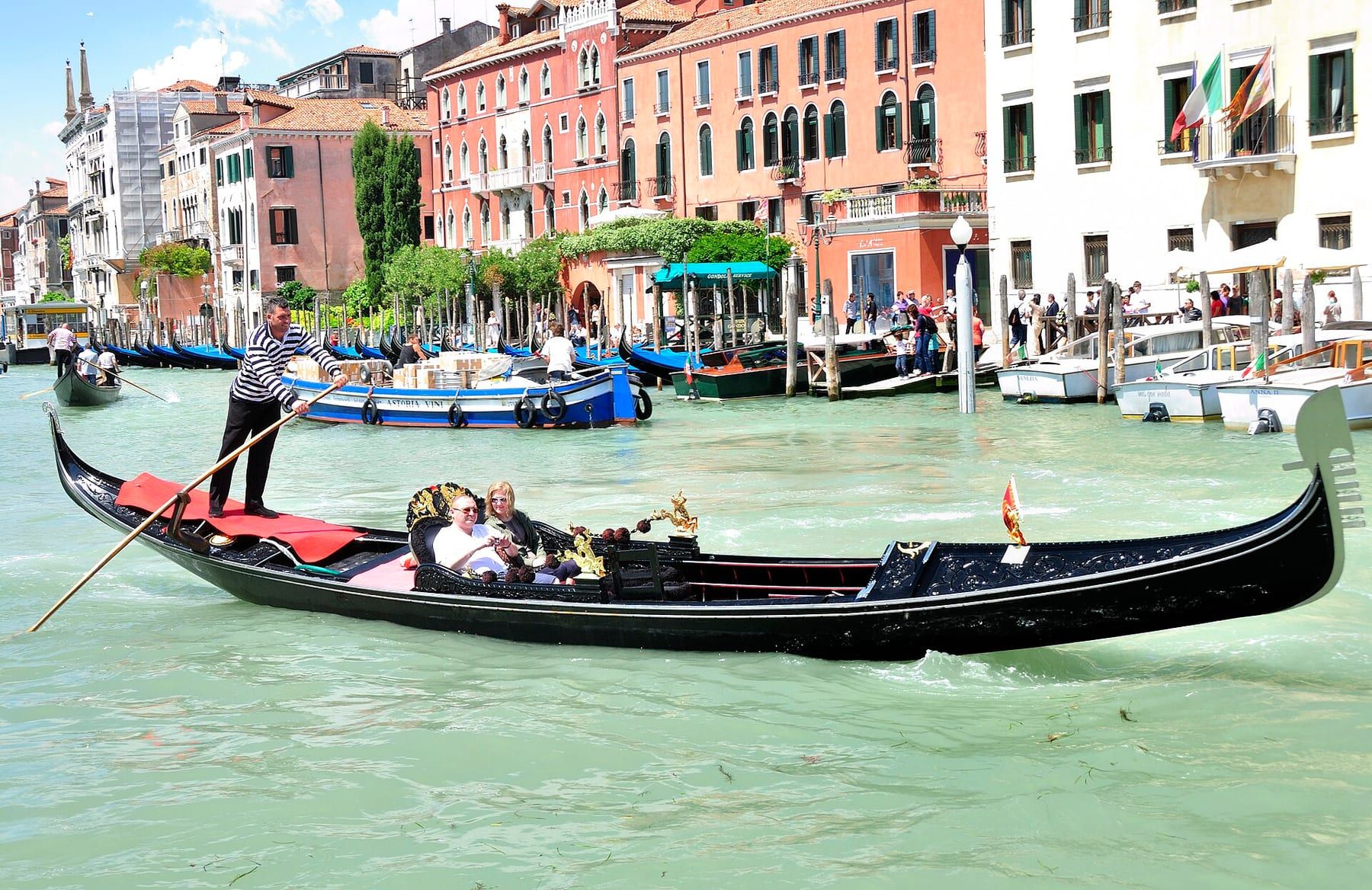 Taxi acqueo illuminato ormeggiato a una riva veneziana di notte