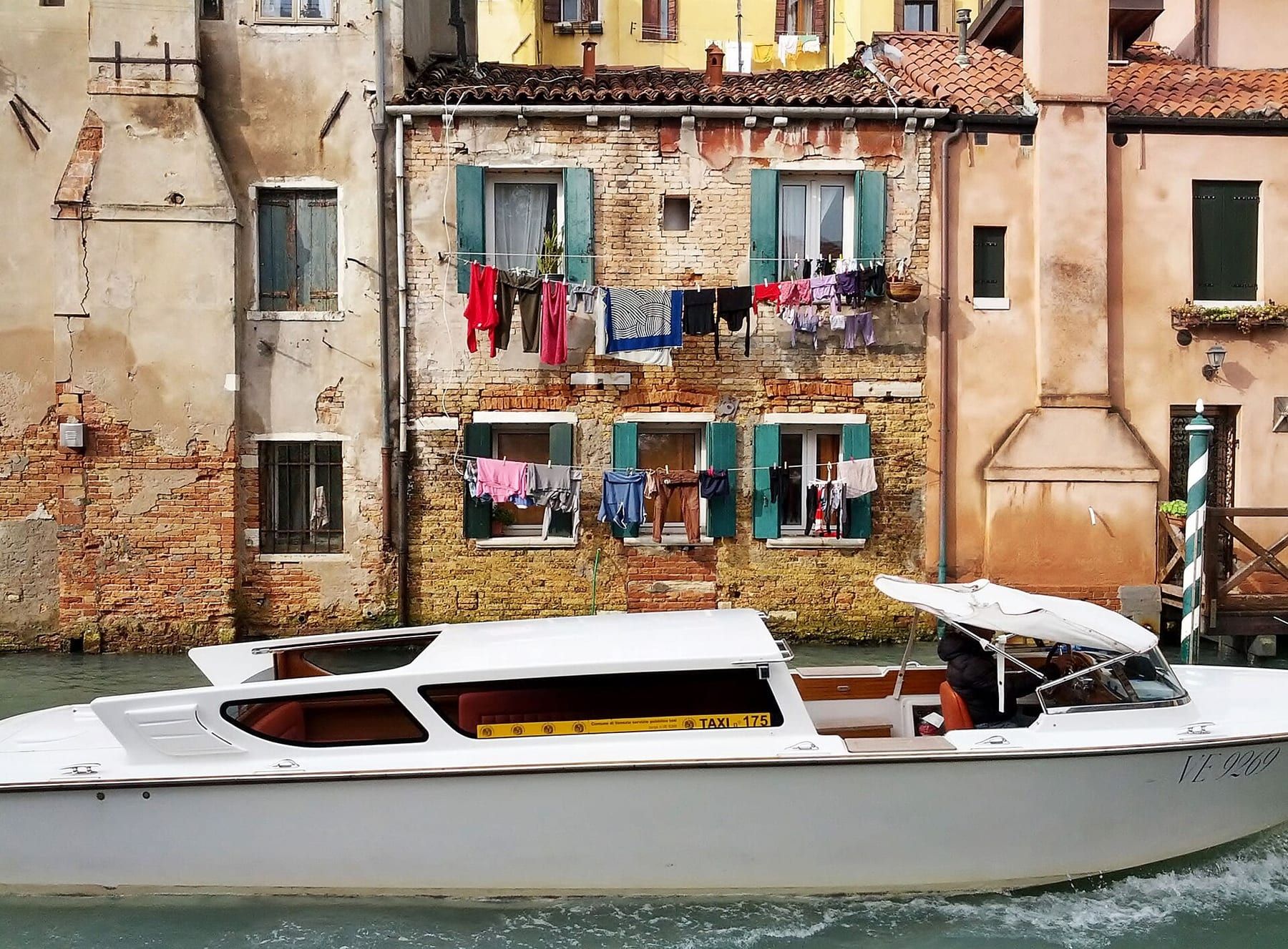 Venetian water taxi with a polished wooden hull moored in a canal